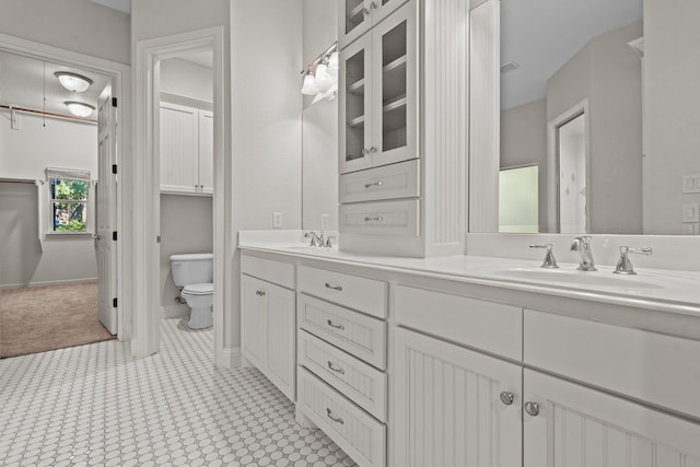 bathroom with tile patterned flooring, vanity, and toilet