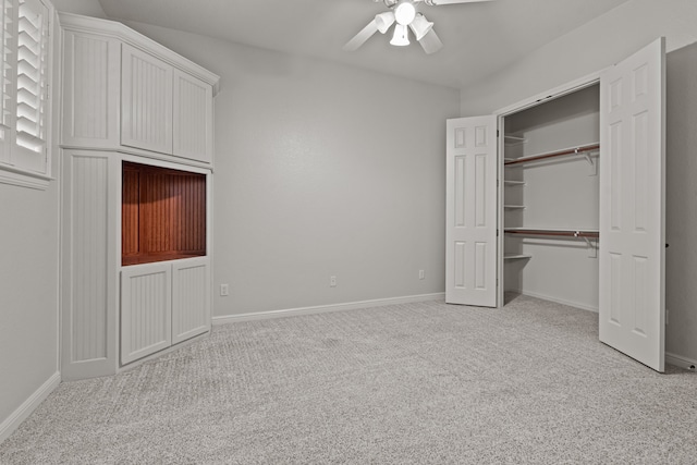 unfurnished bedroom with ceiling fan, light colored carpet, and a closet