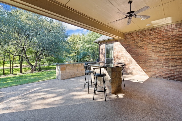 view of patio with exterior bar and ceiling fan