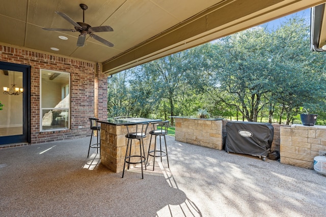 view of patio / terrace featuring area for grilling, ceiling fan, and a bar