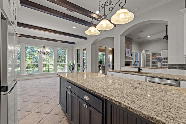 kitchen featuring decorative backsplash, white cabinetry, sink, and pendant lighting