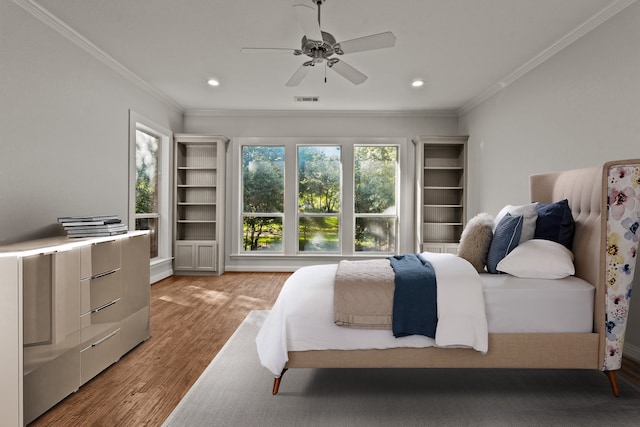 bedroom with light hardwood / wood-style floors, ceiling fan, and crown molding