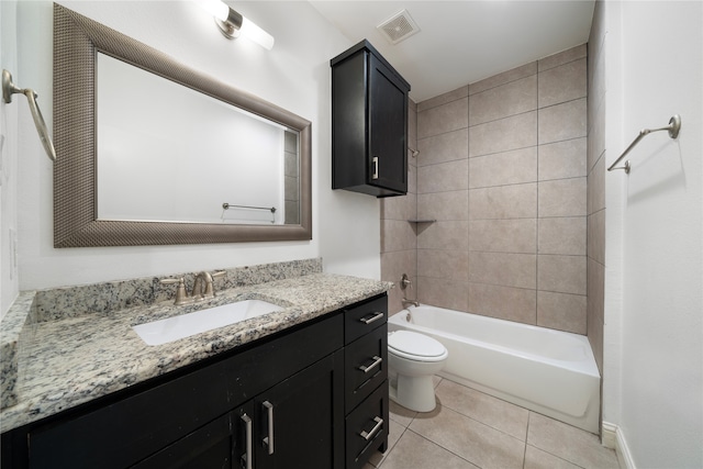 full bathroom with tile patterned flooring, tiled shower / bath, vanity, and toilet