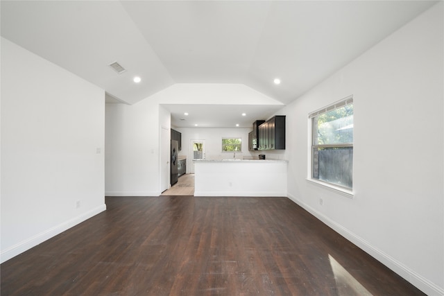 unfurnished living room with vaulted ceiling and dark wood-type flooring