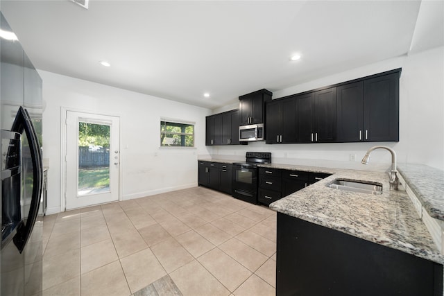 kitchen featuring appliances with stainless steel finishes, light tile patterned flooring, sink, and light stone counters