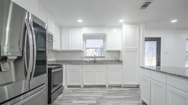 kitchen with light stone countertops, sink, stainless steel appliances, and white cabinets