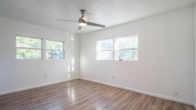 empty room featuring ceiling fan, a textured ceiling, and light hardwood / wood-style floors