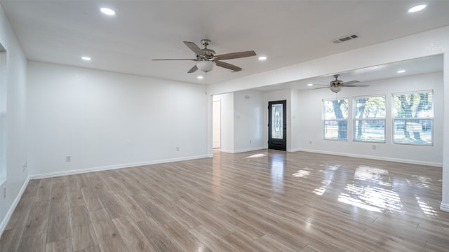 empty room with ceiling fan and light hardwood / wood-style flooring