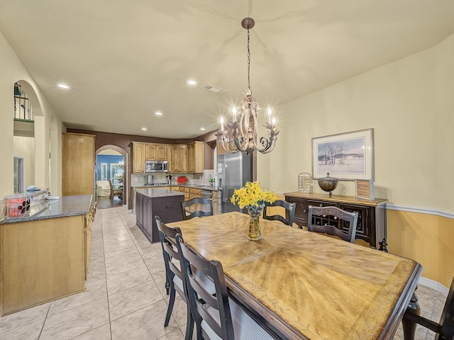 dining space featuring light tile patterned floors and a chandelier