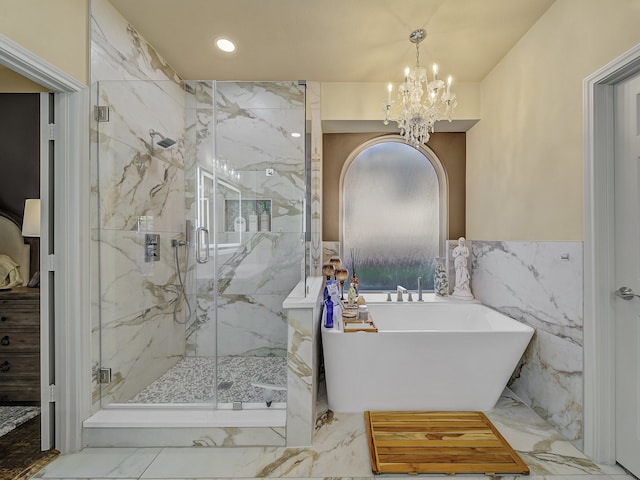 bathroom featuring an inviting chandelier, shower with separate bathtub, and tile walls