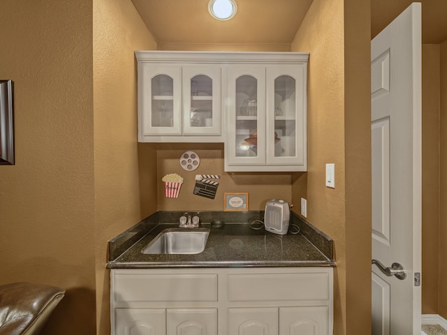 interior space featuring sink and white cabinetry