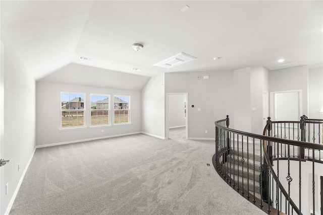 interior space with light carpet and vaulted ceiling