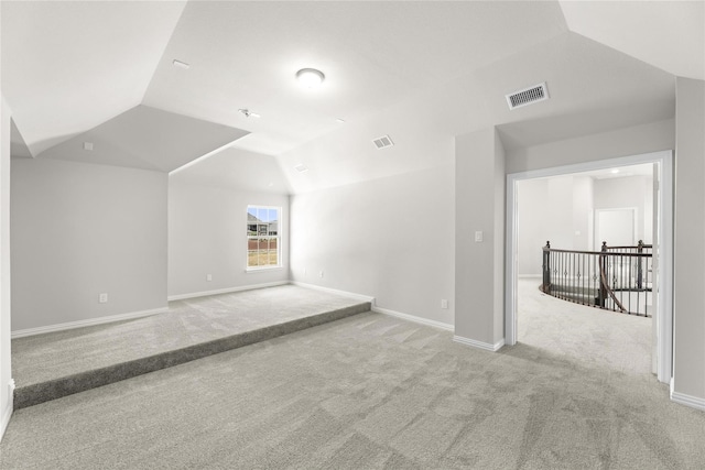 interior space with light carpet and vaulted ceiling