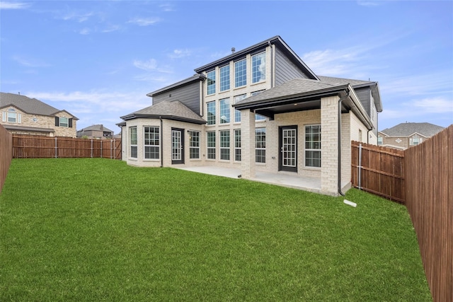 back of house with a yard and a patio