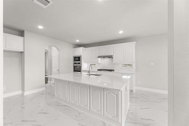 kitchen with a center island with sink, stainless steel appliances, sink, and white cabinetry