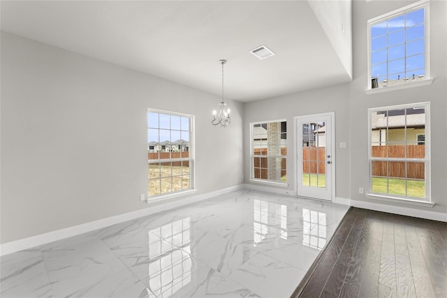 unfurnished dining area featuring hardwood / wood-style flooring and a chandelier