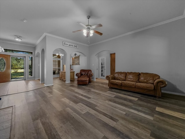 unfurnished living room featuring hardwood / wood-style flooring, ceiling fan with notable chandelier, and crown molding