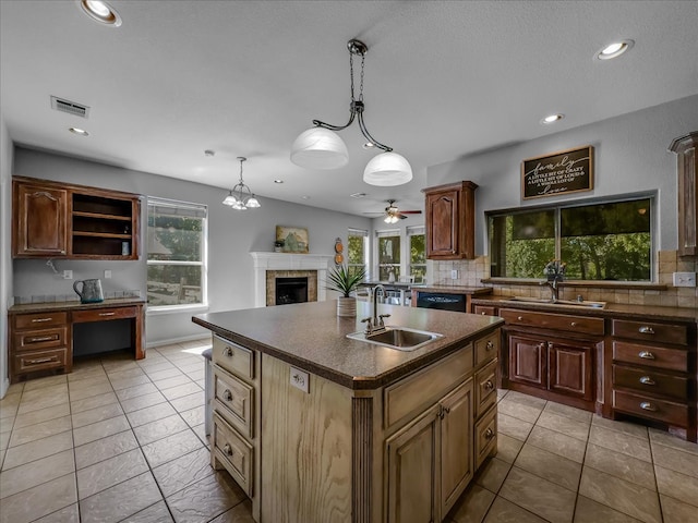 kitchen featuring an island with sink, a wealth of natural light, sink, and decorative backsplash