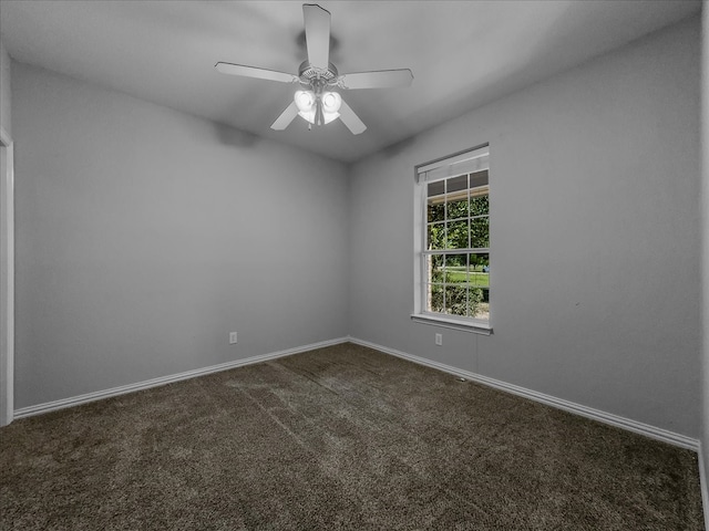 empty room featuring dark carpet and ceiling fan