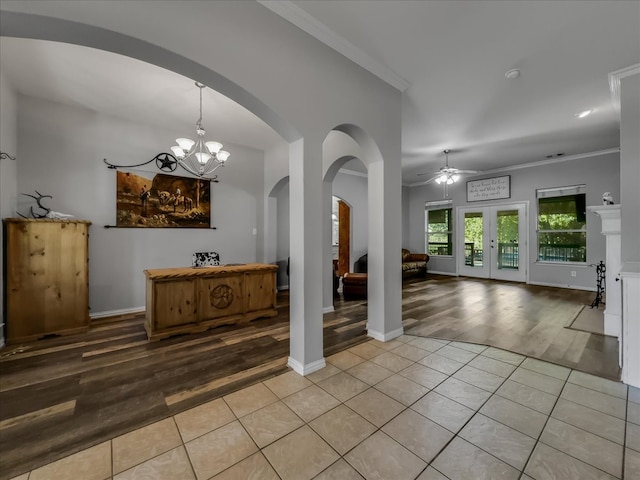 entrance foyer featuring ceiling fan with notable chandelier, ornamental molding, and light hardwood / wood-style flooring