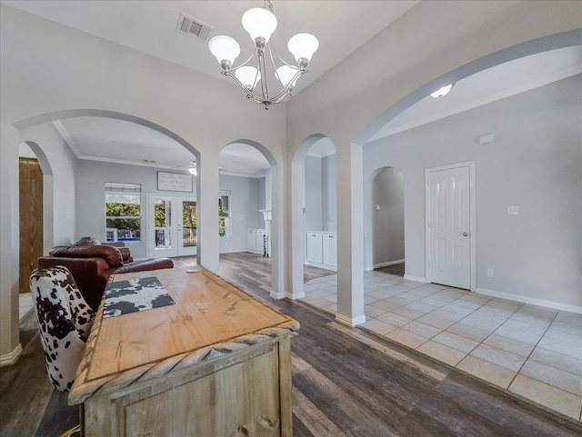 dining room with ornamental molding, hardwood / wood-style floors, french doors, and a notable chandelier