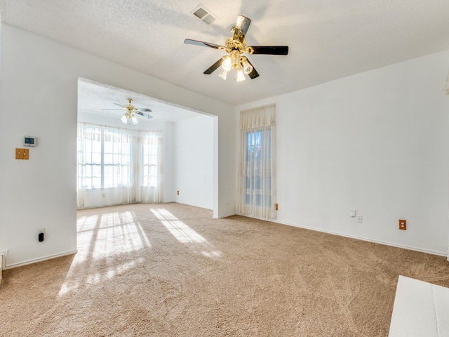 carpeted empty room with ceiling fan and a textured ceiling