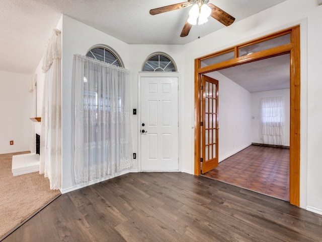 foyer featuring ceiling fan, a textured ceiling, and dark wood-type flooring