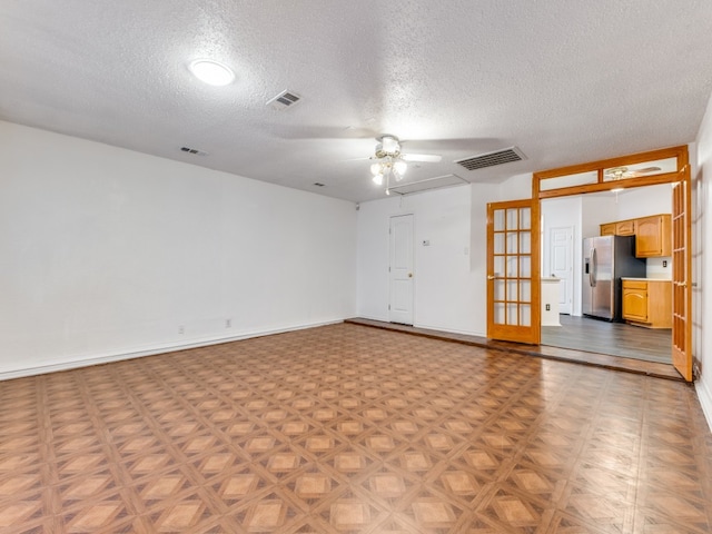 spare room with a textured ceiling, light parquet floors, and ceiling fan