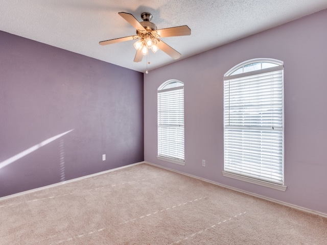 carpeted spare room with ceiling fan and a textured ceiling