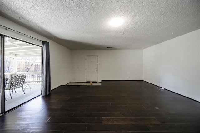 unfurnished room featuring a textured ceiling and dark hardwood / wood-style floors