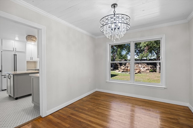 unfurnished dining area featuring dark hardwood / wood-style flooring, crown molding, plenty of natural light, and an inviting chandelier