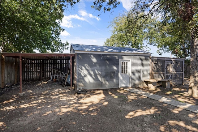 back of house featuring an outbuilding and a carport