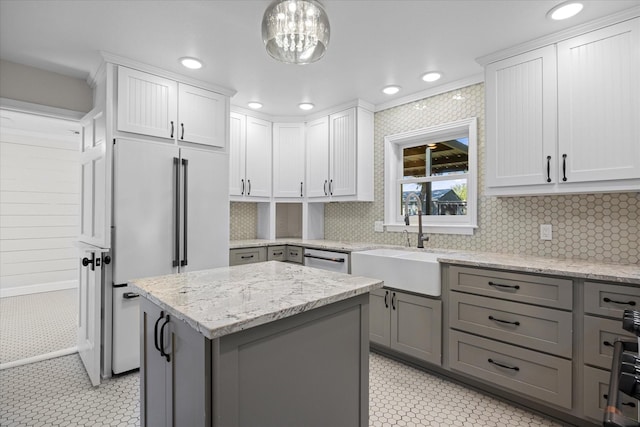 kitchen featuring a sink, a kitchen island, recessed lighting, and high end fridge