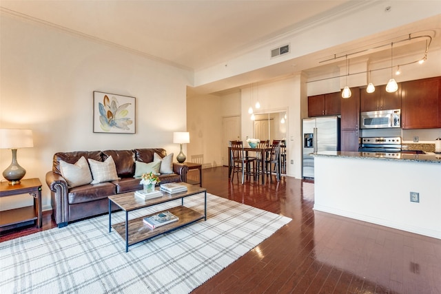 living room with dark hardwood / wood-style flooring and crown molding