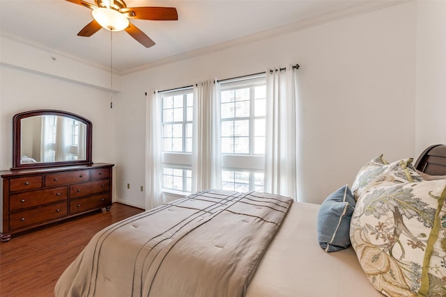 bedroom featuring ceiling fan, hardwood / wood-style floors, and crown molding