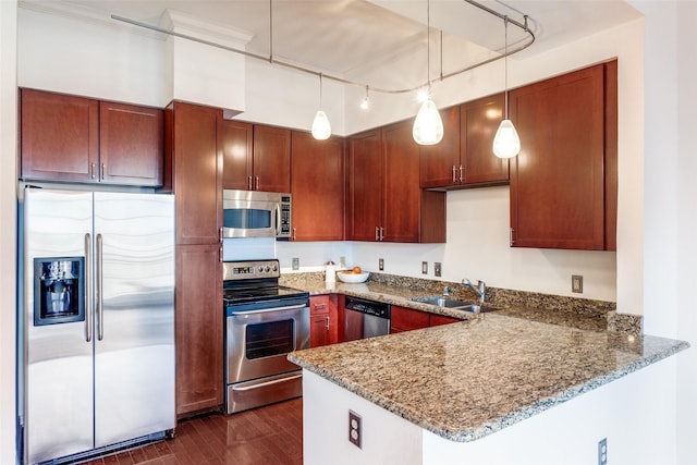 kitchen featuring sink, hanging light fixtures, stone countertops, and appliances with stainless steel finishes