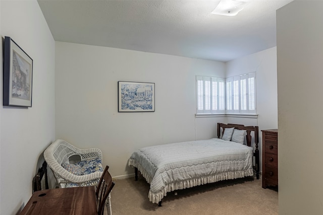 bedroom featuring light colored carpet and a textured ceiling