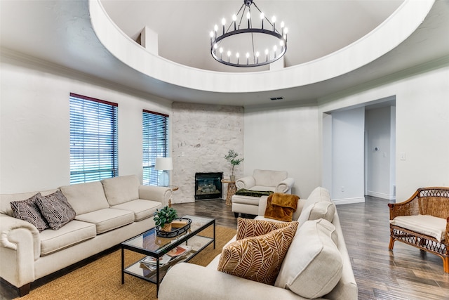 living room with a notable chandelier, hardwood / wood-style floors, a raised ceiling, and a fireplace