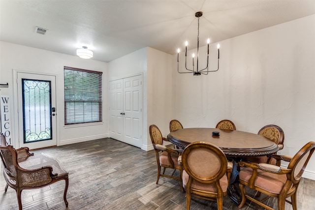 dining area with an inviting chandelier and dark hardwood / wood-style flooring