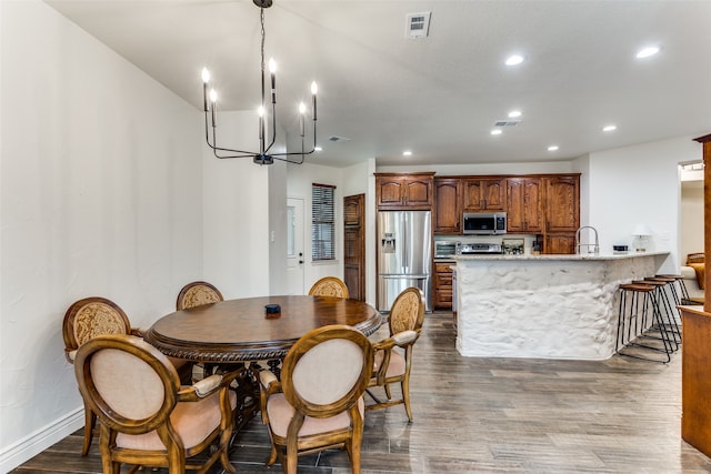 dining room featuring hardwood / wood-style floors, sink, and a notable chandelier