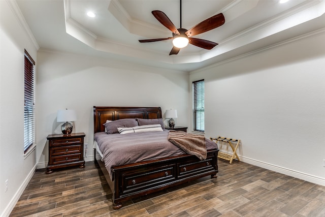 bedroom with ceiling fan, a raised ceiling, dark hardwood / wood-style floors, and crown molding