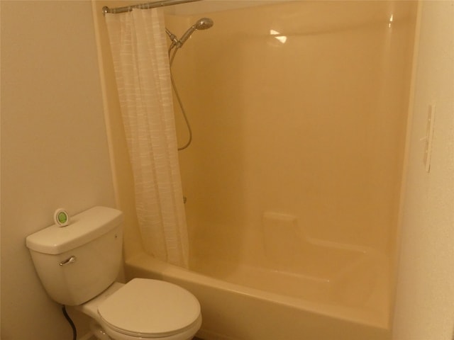 bathroom featuring shower / tub combo and toilet