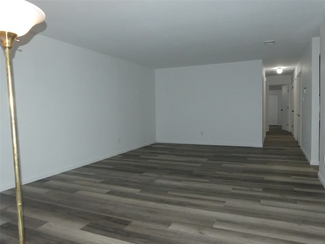 unfurnished room with dark wood-type flooring