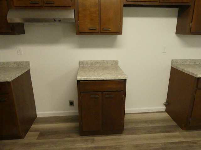 kitchen featuring dark brown cabinetry and dark hardwood / wood-style floors