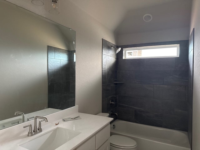 full bathroom featuring vanity, toilet, tiled shower / bath, and vaulted ceiling