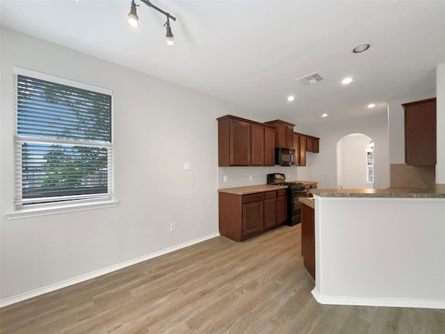 kitchen with black appliances, light hardwood / wood-style floors, and kitchen peninsula