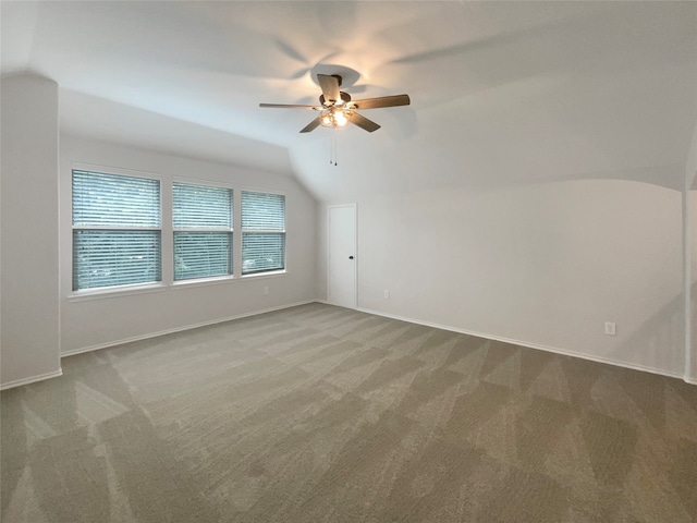 interior space featuring vaulted ceiling, ceiling fan, and carpet flooring