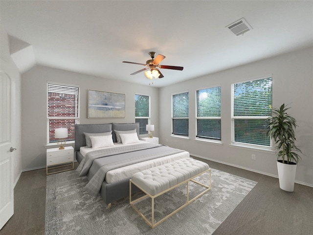 bedroom featuring dark carpet, lofted ceiling, multiple windows, and ceiling fan