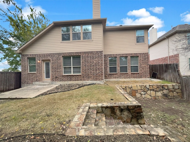 back of house with a lawn and a patio area