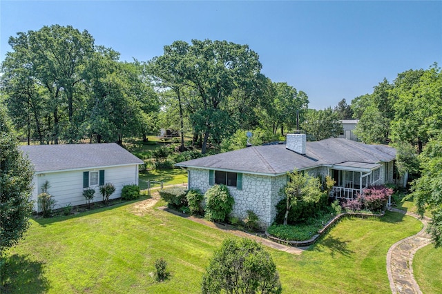 1498 Riley Rd, Whitesboro, TX 76273 - exterior space with a yard, stone siding, a chimney, a sunroom, and view of scattered trees